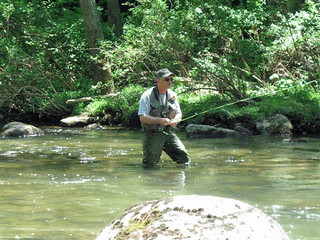 Photo of man Fly fishing while wading in a stream
